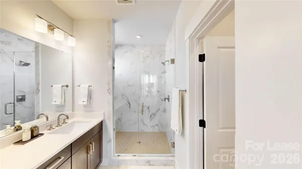 a bathroom with a mirror a shower and vanity