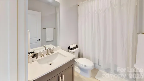 a bathroom with a sink a toilet and shower curtain