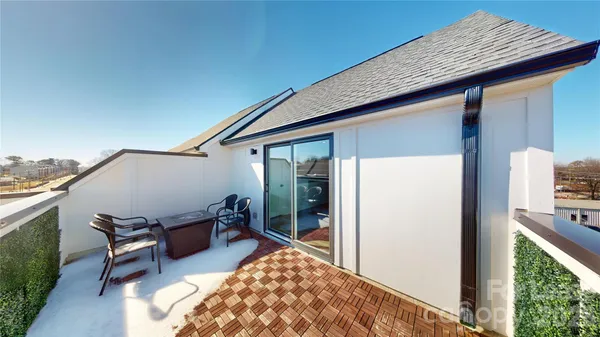 a patio with table and chairs and potted plants