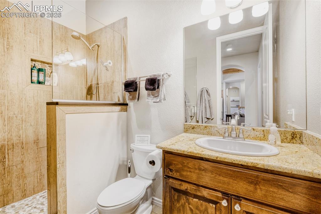 4519 Edwards Place Cascade, CO 80809 - Photo 25 of 47 Main level three quarter bathroom with walk in shower, and granite vanity located next to the secondary bedroom