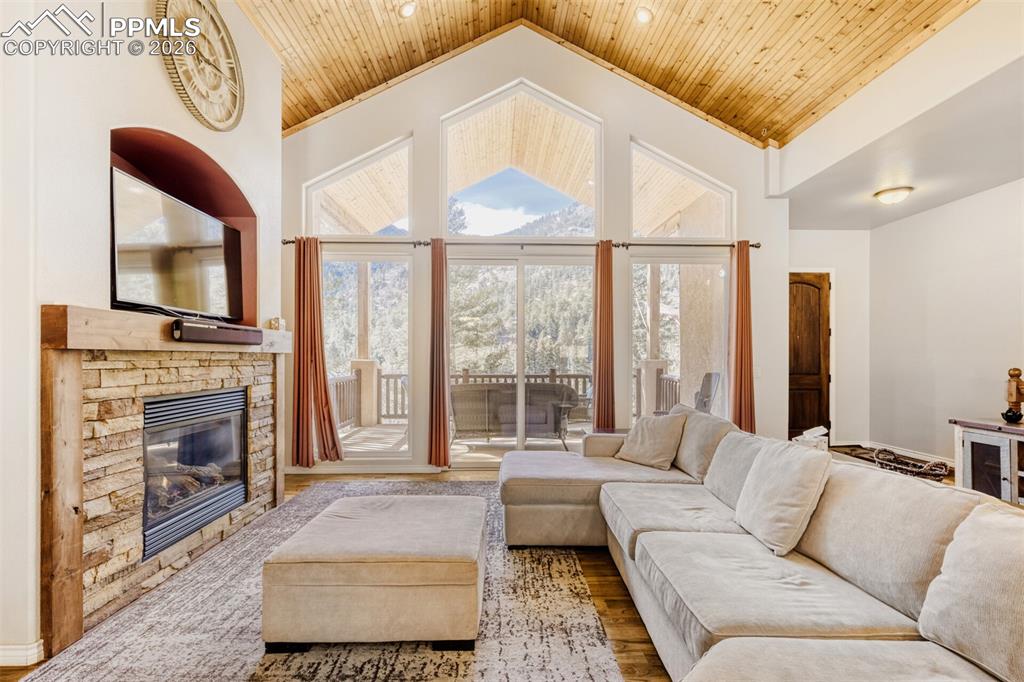 4519 Edwards Place Cascade, CO 80809 - Photo 8 of 47 Living area with soaring wooden ceiling, a fireplace, and wood floors- the perfect mountain getaway