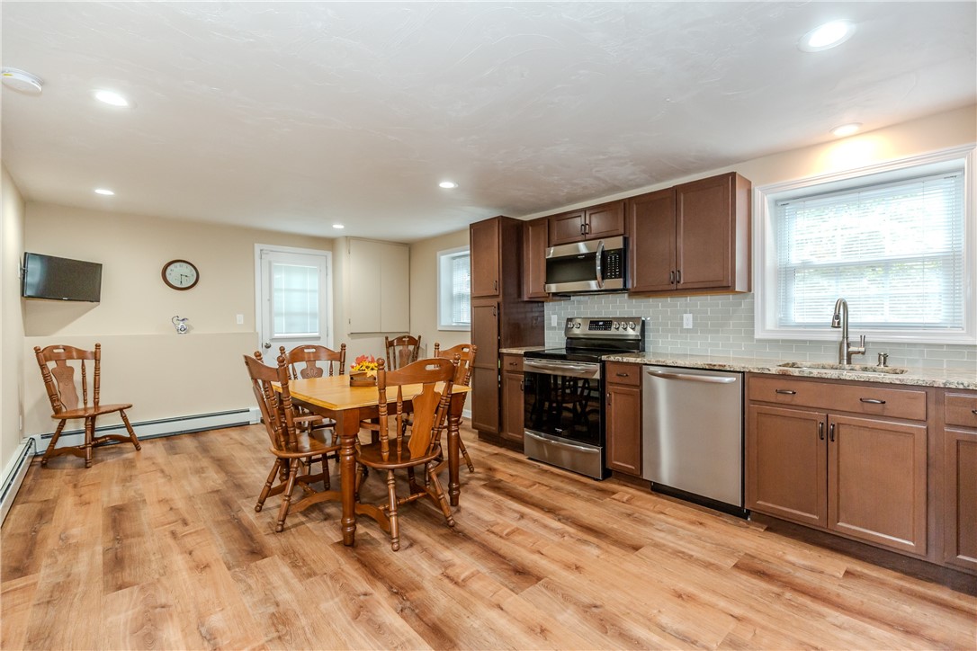 99 Tower Hill Road Cumberland, RI 02864 - Photo 29 of 43 Lower-level kitchen with a view of the door leading to the beautiful yard, creating a bright and inviting connection to the outdoors.