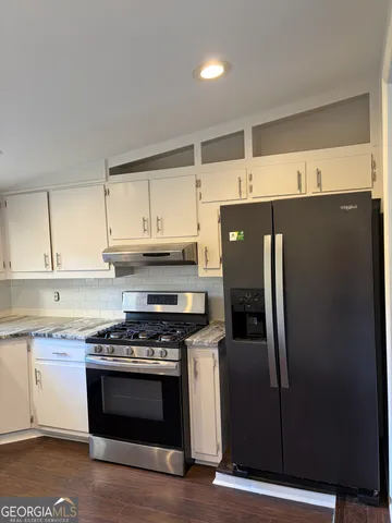 a kitchen with stainless steel appliances granite countertop a refrigerator and a stove