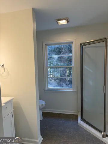 a view of an empty room with window and closet area