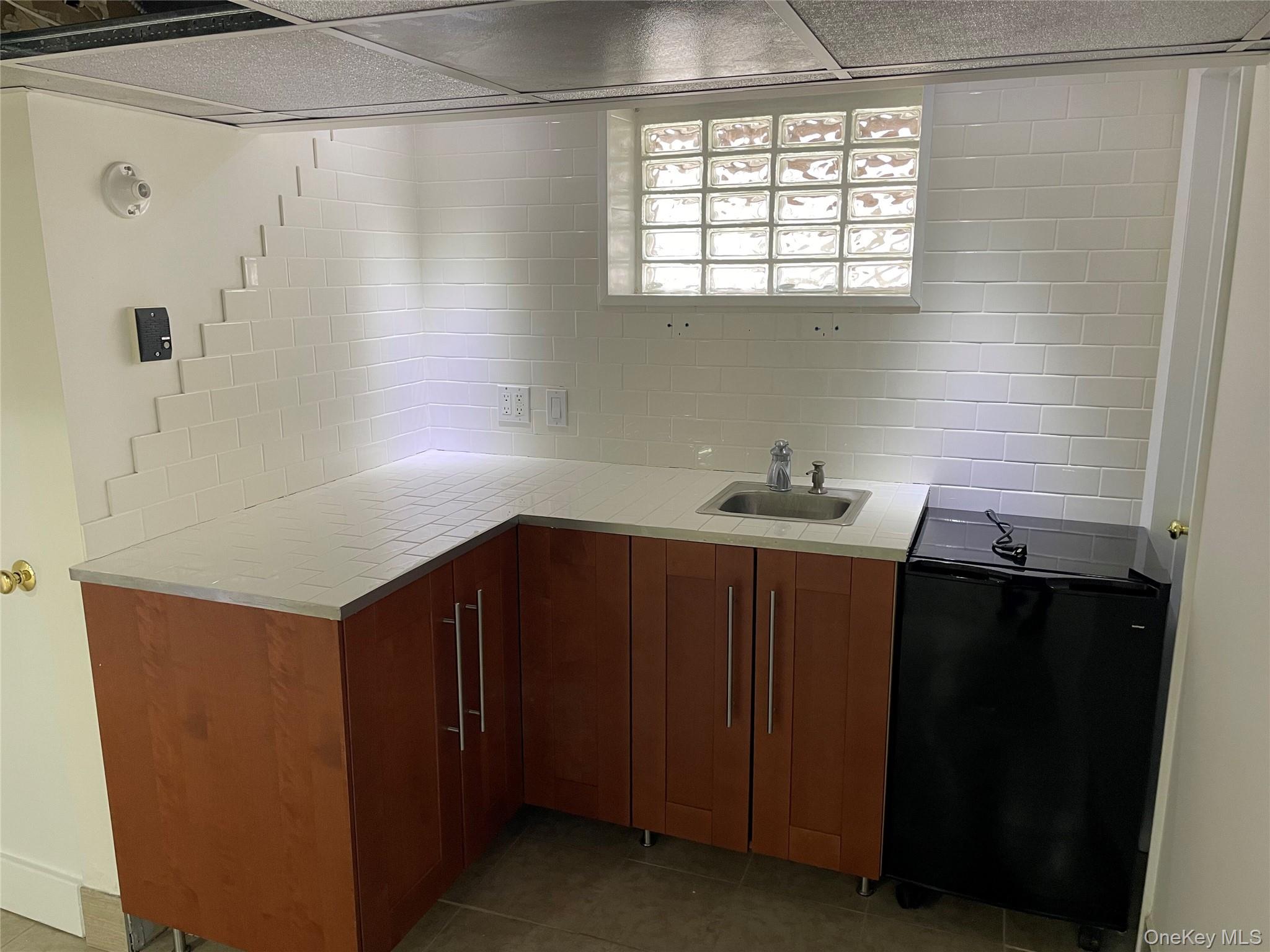 8 Cameron Lane Valley Stream, NY 11581 - Photo 22 of 33 Basement sink w/ cabinets and mini fridge