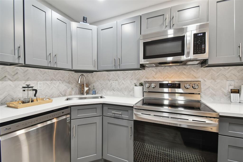 8901 Blind Pass Road, Unit 228 St. Pete Beach, FL 33706 - Photo 11 of 29 a kitchen with a sink stove and microwave