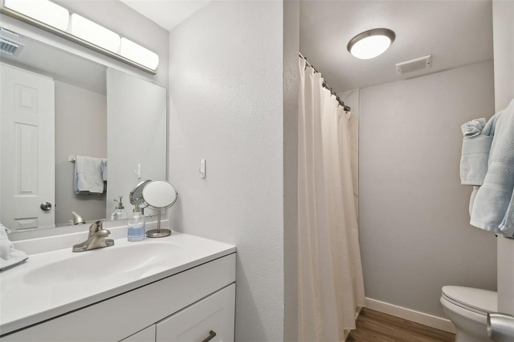 8901 Blind Pass Road, Unit 228 St. Pete Beach, FL 33706 - Photo 18 of 29 a bathroom with a sink toilet and mirror