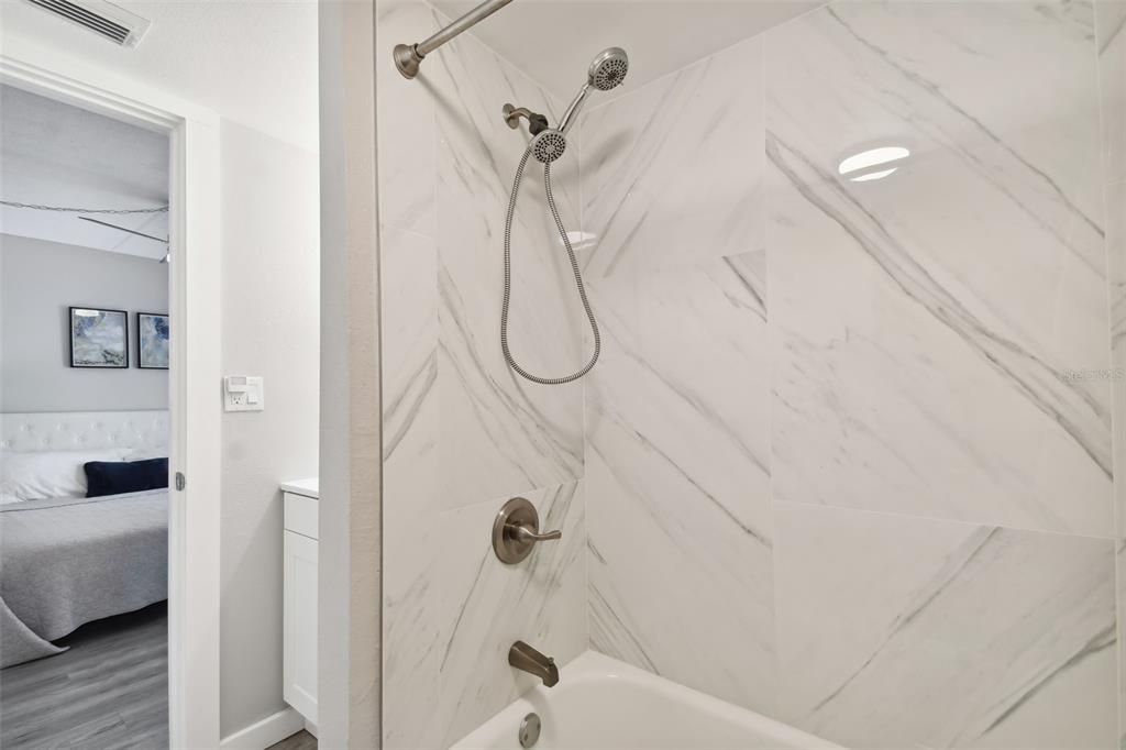 8901 Blind Pass Road, Unit 228 St. Pete Beach, FL 33706 - Photo 20 of 29 a bathroom with a glass shower door