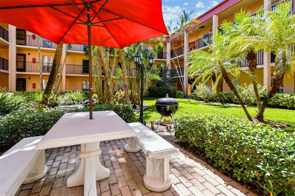 8901 Blind Pass Road, Unit 228 St. Pete Beach, FL 33706 - Photo 23 of 29 a patio with a yard and plants