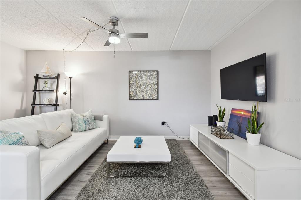 8901 Blind Pass Road, Unit 228 St. Pete Beach, FL 33706 - Photo 5 of 29 a living room with furniture and a flat screen tv