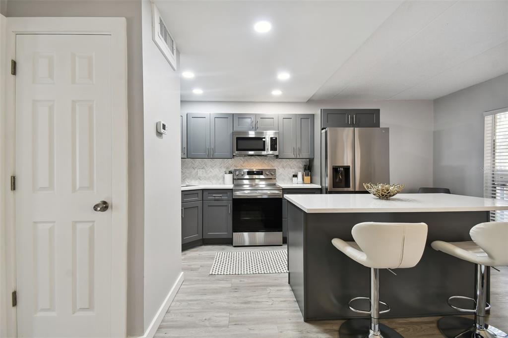 8901 Blind Pass Road, Unit 228 St. Pete Beach, FL 33706 - Photo 10 of 29 a large kitchen with a table and chairs