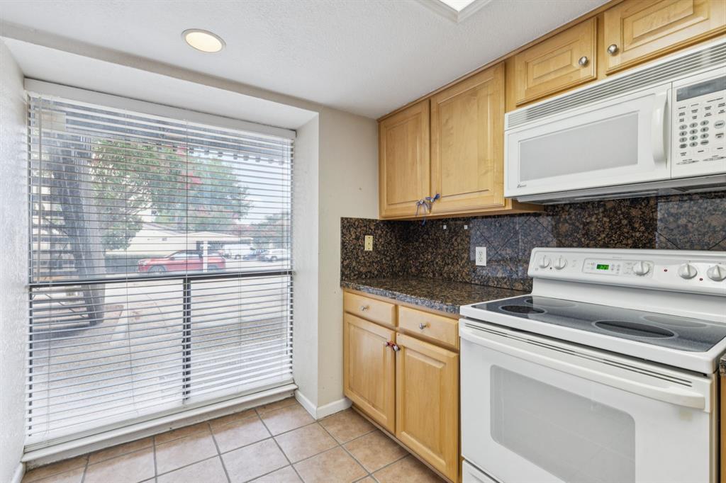 4569 North O'Connor Road, Unit 1320 Irving, TX 75062 - Photo 10 of 24 a kitchen with white cabinets and a stove top oven