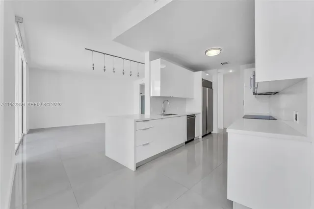 a kitchen with white cabinets and white appliances