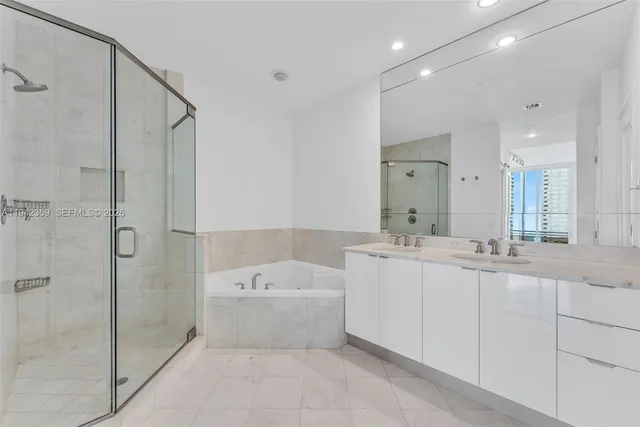 a bathroom with a bathtub shower sink mirror and toilet