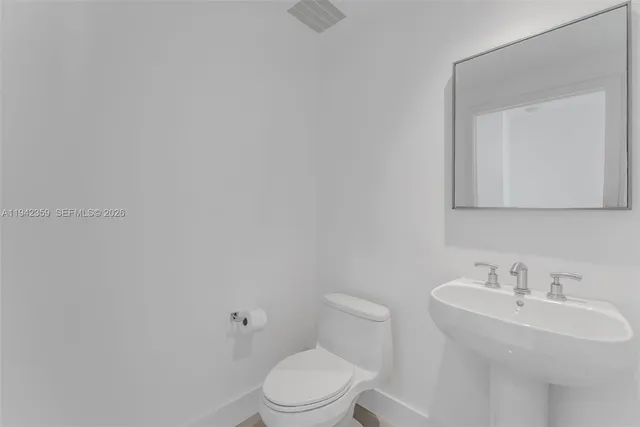 a white toilet sitting next to a bathroom sink