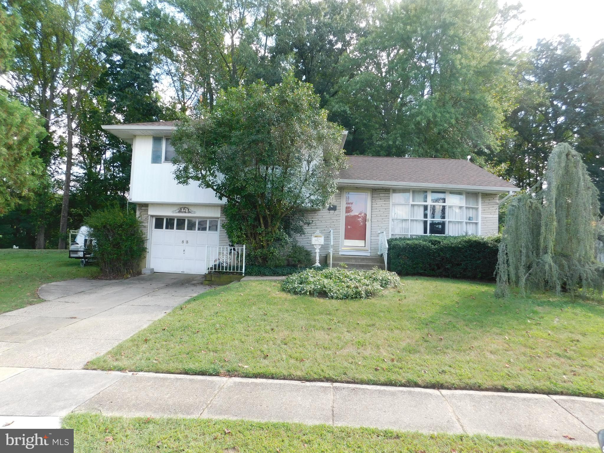 53 Lillian Place Glendora, NJ 08029 - Photo 2 of 6 a front view of a house with a yard and garage