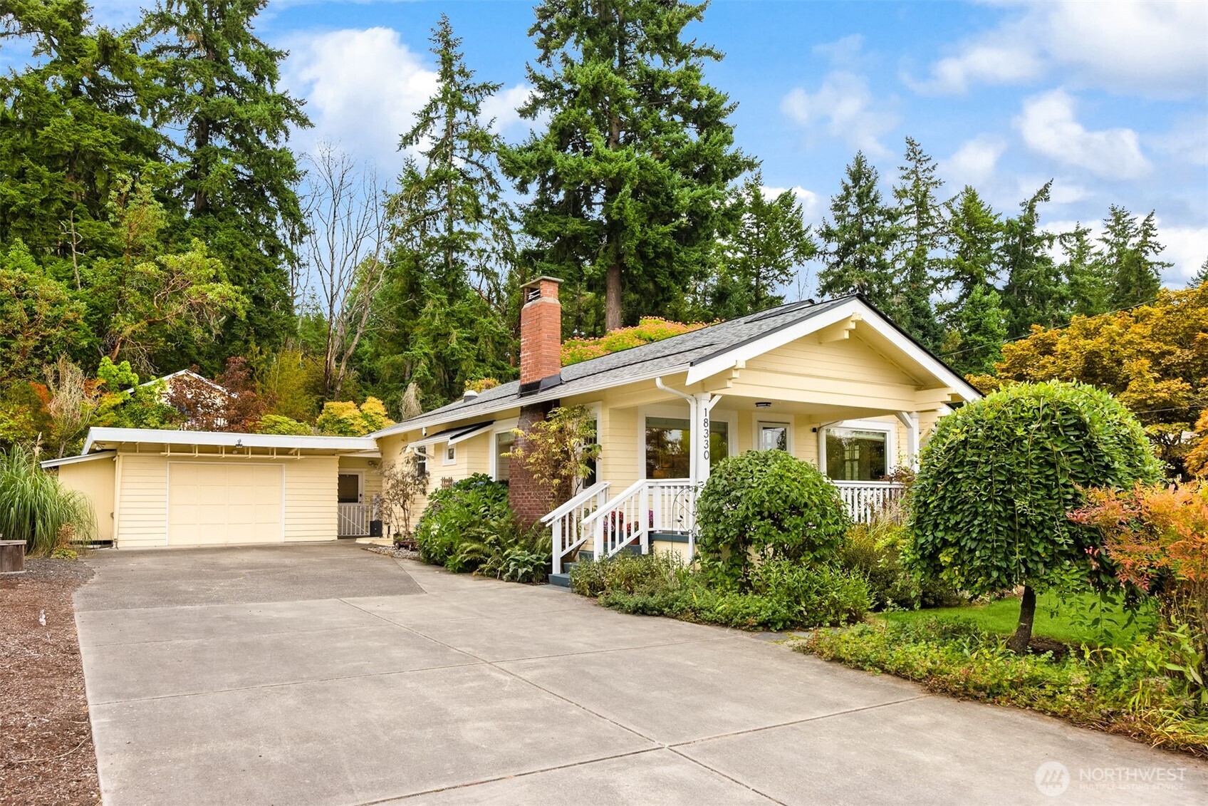 18330 9th Avenue Northeast Poulsbo, WA 98370 - Photo 2 of 32 a view of a yard in front of a house with plants and large trees