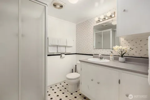 a bathroom with a sink a toilet and mirror