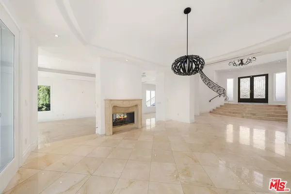 a view of an empty room with a fireplace and a window