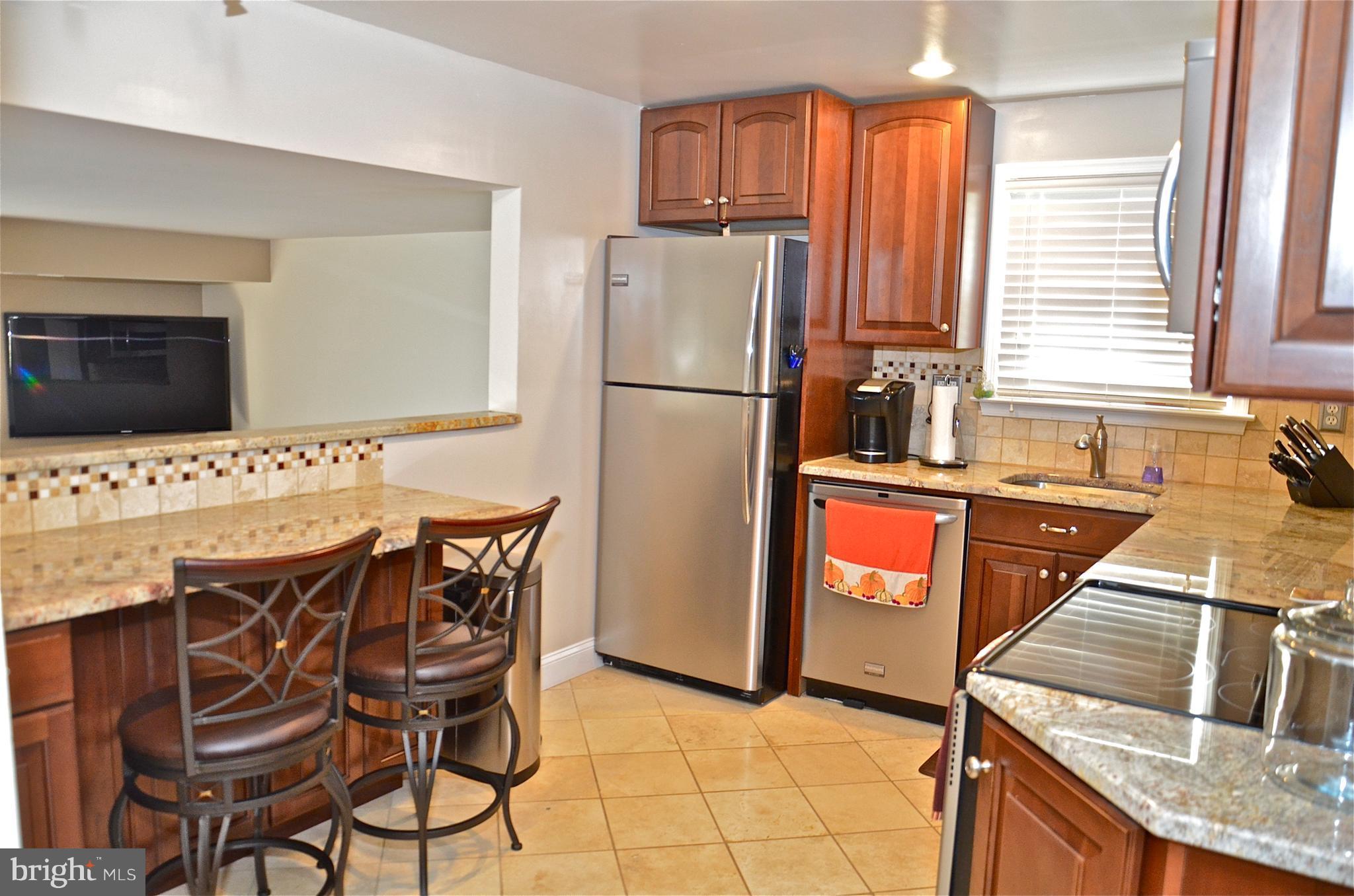 9229 Bowline Road Baltimore, MD 21236 - Photo 11 of 24 a kitchen with stainless steel appliances granite countertop a refrigerator and a stove top oven