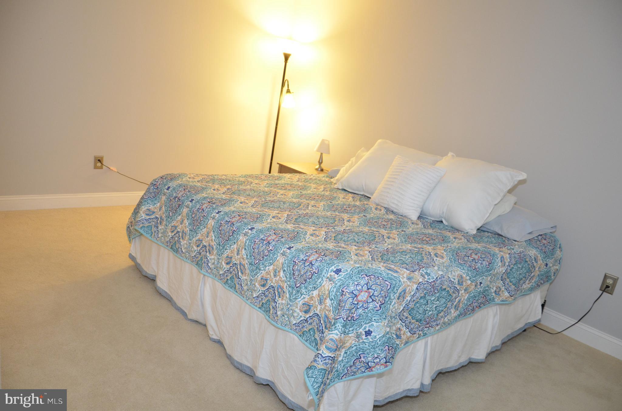 9229 Bowline Road Baltimore, MD 21236 - Photo 13 of 24 a bed sitting in a bedroom next to a lamp