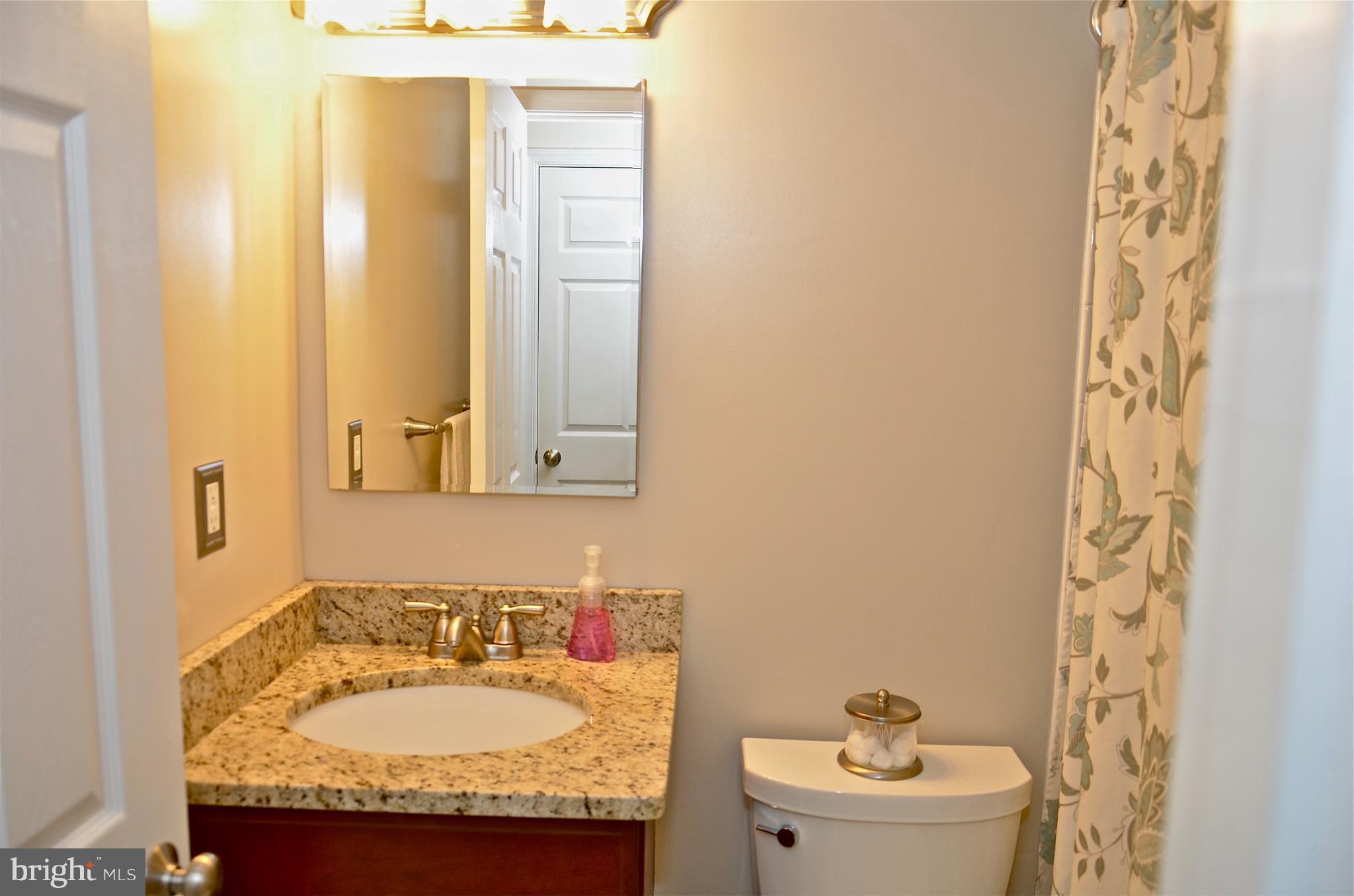9229 Bowline Road Baltimore, MD 21236 - Photo 18 of 24 a bathroom with a granite countertop sink and a mirror