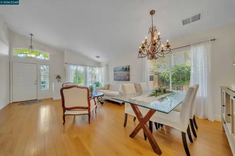 a living room with stainless steel appliances granite countertop furniture and a view of kitchen