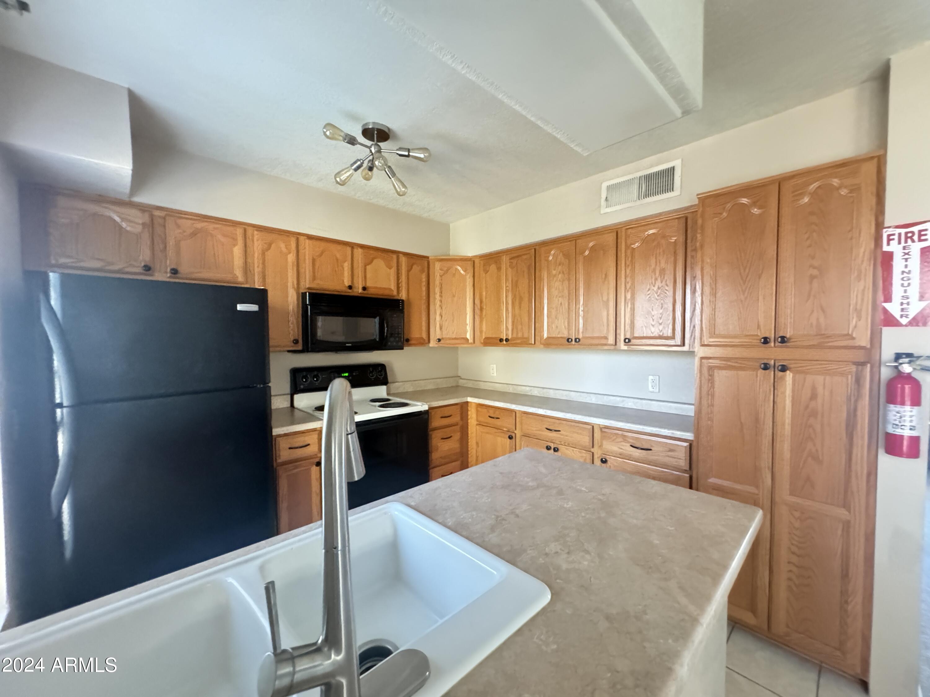 8020 East Thomas Road, Unit 226 Scottsdale, AZ 85251 - Photo 16 of 16 a kitchen with stainless steel appliances granite countertop a refrigerator and a sink