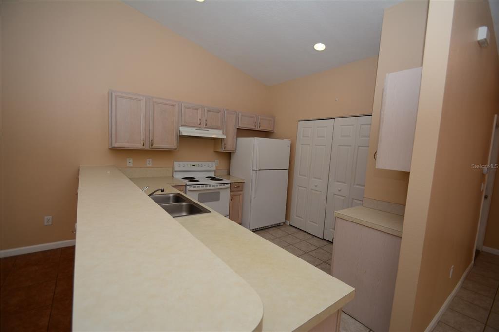37 Eton Lane, Unit A Palm Coast, FL 32164 - Photo 11 of 34 a kitchen with a refrigerator a stove top oven and white cabinets