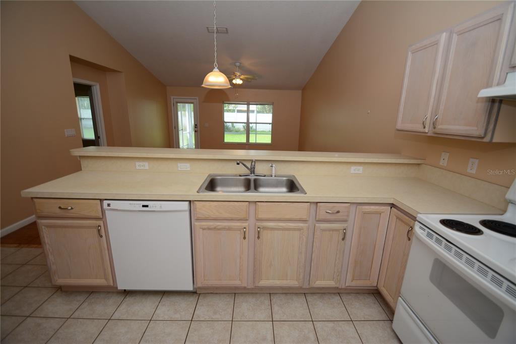 37 Eton Lane, Unit A Palm Coast, FL 32164 - Photo 13 of 34 a kitchen with granite countertop white cabinets white appliances with a sink and dishwasher
