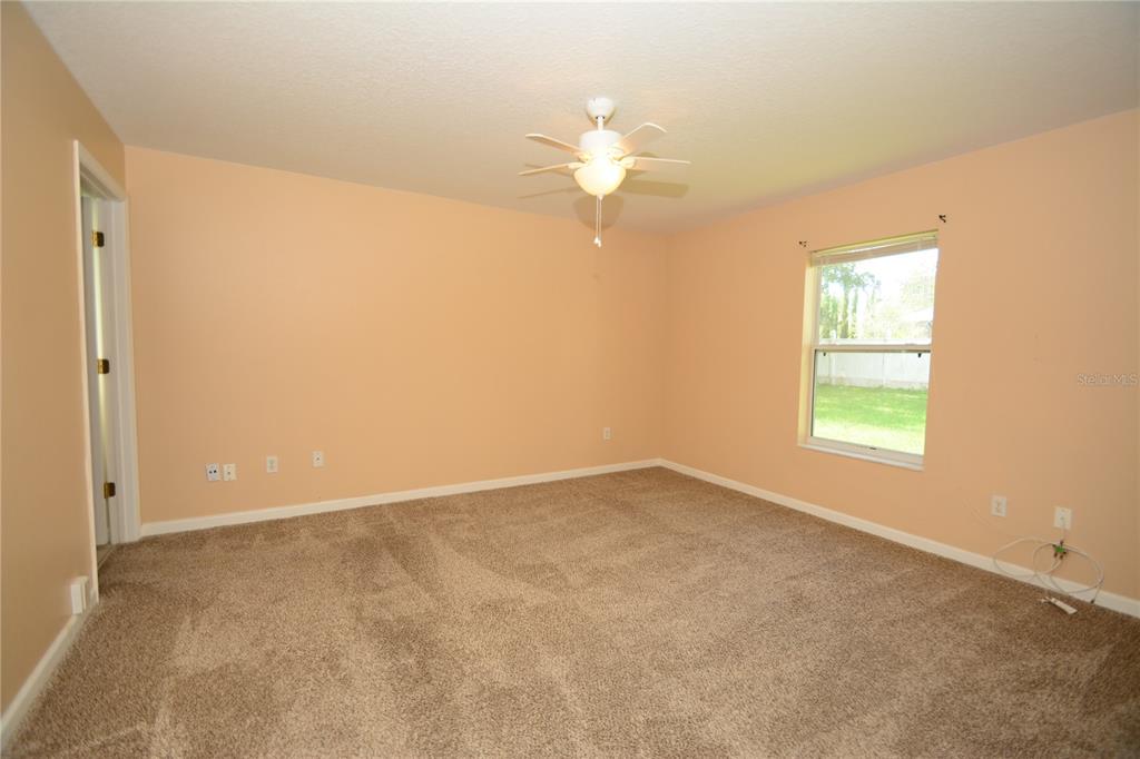 37 Eton Lane, Unit A Palm Coast, FL 32164 - Photo 21 of 34 an empty room with a window and a fan