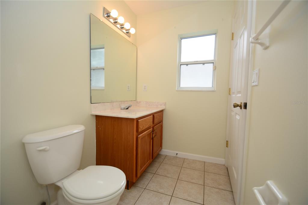 37 Eton Lane, Unit A Palm Coast, FL 32164 - Photo 24 of 34 a bathroom with a sink a toilet and mirror
