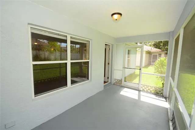 an empty room with sliding glass door and windows