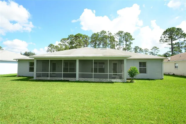 a view of a house with a yard and sitting area