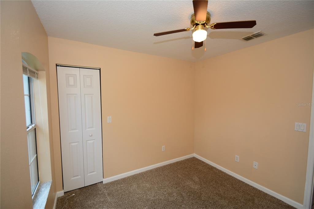 37 Eton Lane, Unit A Palm Coast, FL 32164 - Photo 32 of 34 an empty room with ceiling fan and window