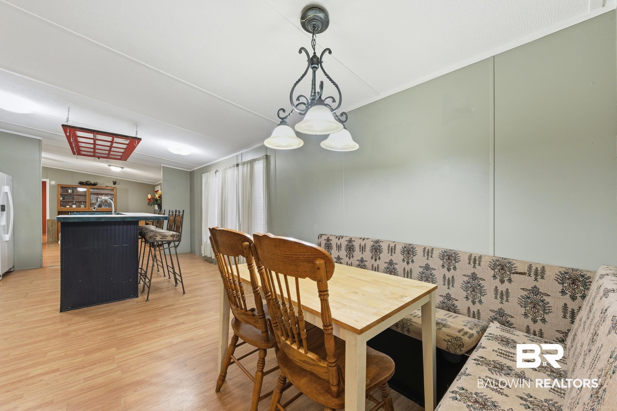 926 Tumbling Lane Atmore, AL 36502 - Photo 26 of 56 Dining area featuring wood-finish flooring, a built-in banquette, and a decorative overhead light fixture