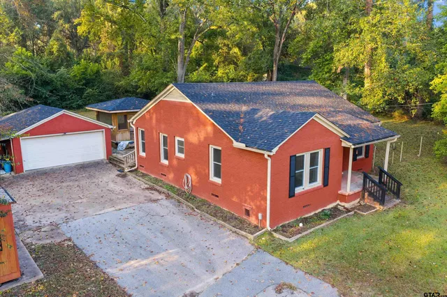 a view of a house with backyard and trees