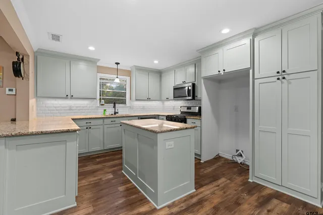 a kitchen with a sink cabinets stainless steel appliances and a window