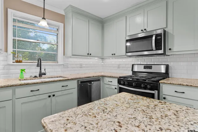 a kitchen with stainless steel appliances a stove sink microwave and cabinets