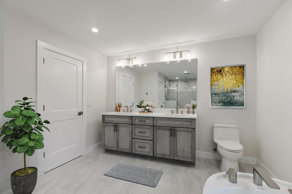 4 Adams Street Wakefield, MA 01880 - Photo 13 of 41 a spacious bathroom with a granite countertop toilet a sink and a mirror