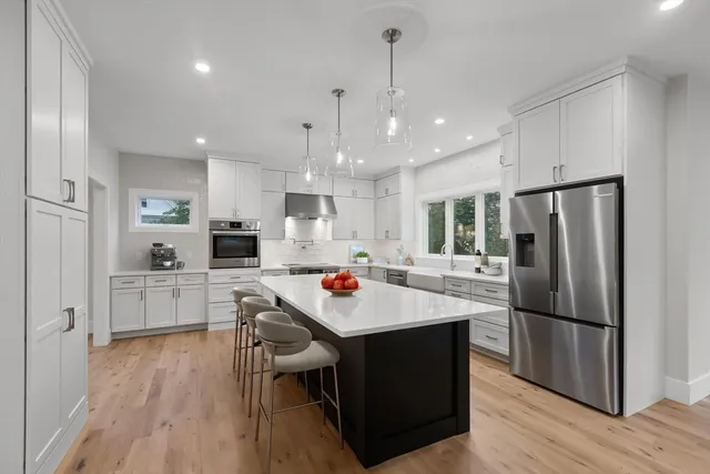 a kitchen that has a lot of cabinets a sink and appliances in it