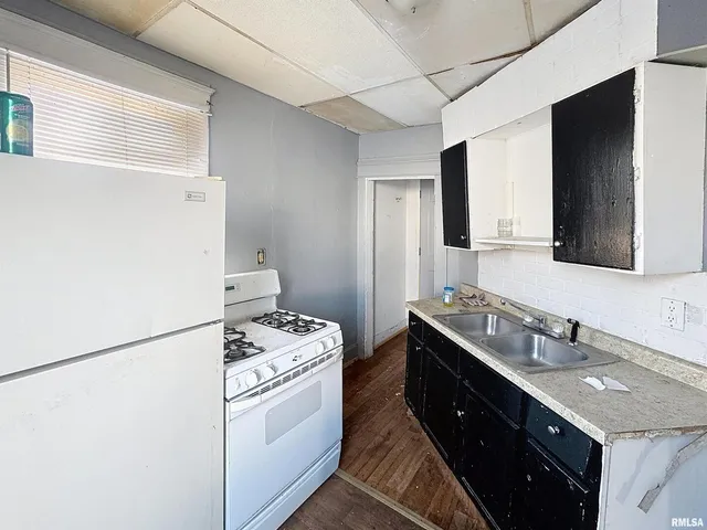 a white toilet sitting next to a bathroom sink and a mirror