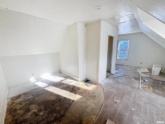 a room with a bed and a refrigerator