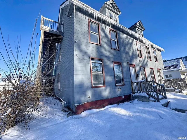 a tall building with a large window and wooden fence