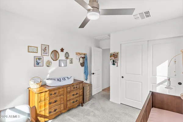 a spacious bedroom with a bed and a dresser