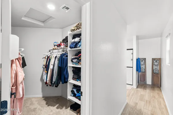 a view of walk in closet with clothes and shoes