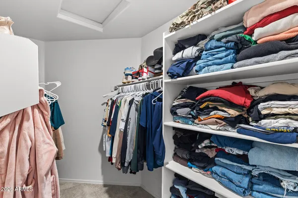 a view of walk in closet with clothes and shoes