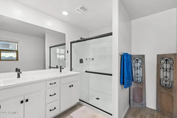 a spacious bathroom with double sink and a mirror