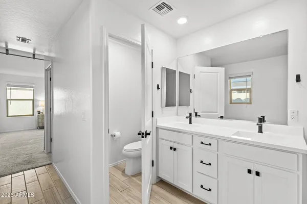 a spacious bathroom with a granite countertop sink toilet mirror and
