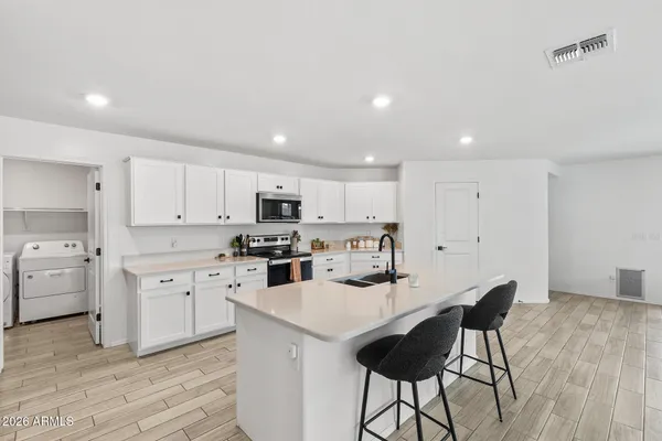 a kitchen with white cabinets and stainless steel appliances